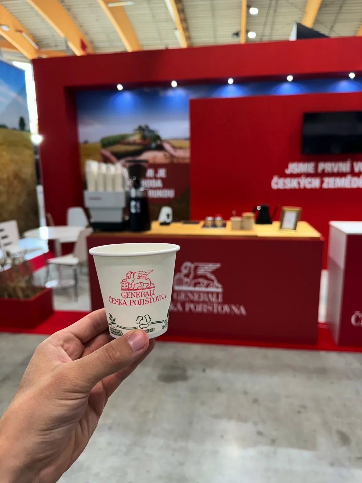 Kávový catering pro firmy – kelímek Generali, mobilní kavárna v pozadí