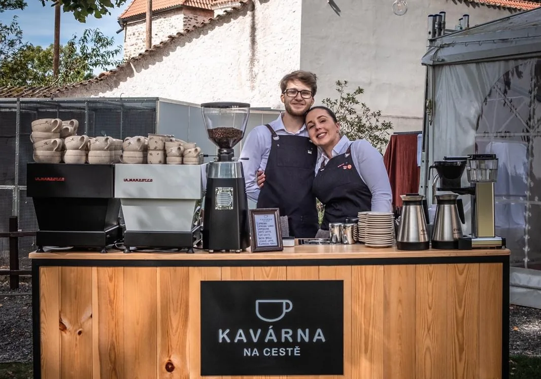 Oba baristi Kavárna na cestě u stánku s logem – barista vs. pronájem kávovaru